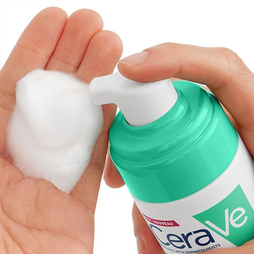 Someone pumping CeraVe Air Foam Cleanser into their palm